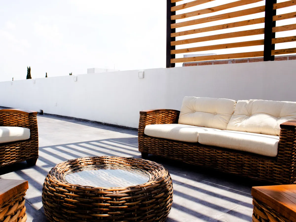 Terrasse carrelée en dalles grises, salon de jardin en résine tressée