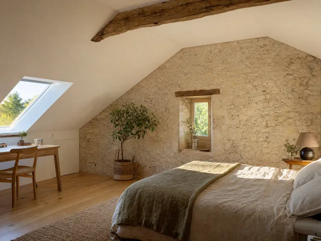 Après : une chambre sous les toits, pentes blanches, panne en chêne et pignon en pierre apparente