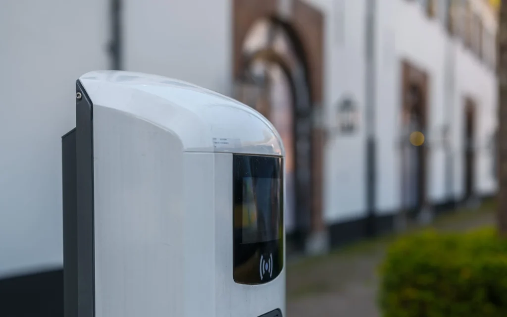 Borne de recharge pour véhicule électrique avec connecteur Type 2 branché, en zone résidentielle