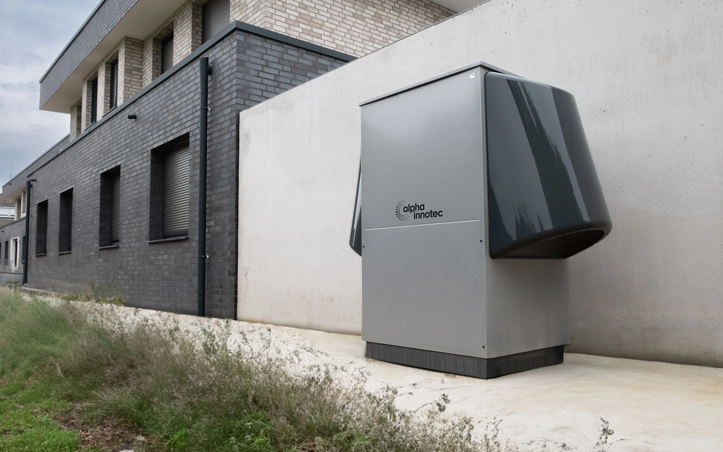 Groupe extérieur d'une pompe à chaleur air/eau installé le long d'un mur