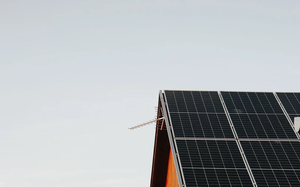 Maison équipée de panneaux photovoltaïques en toiture, au coucher du soleil