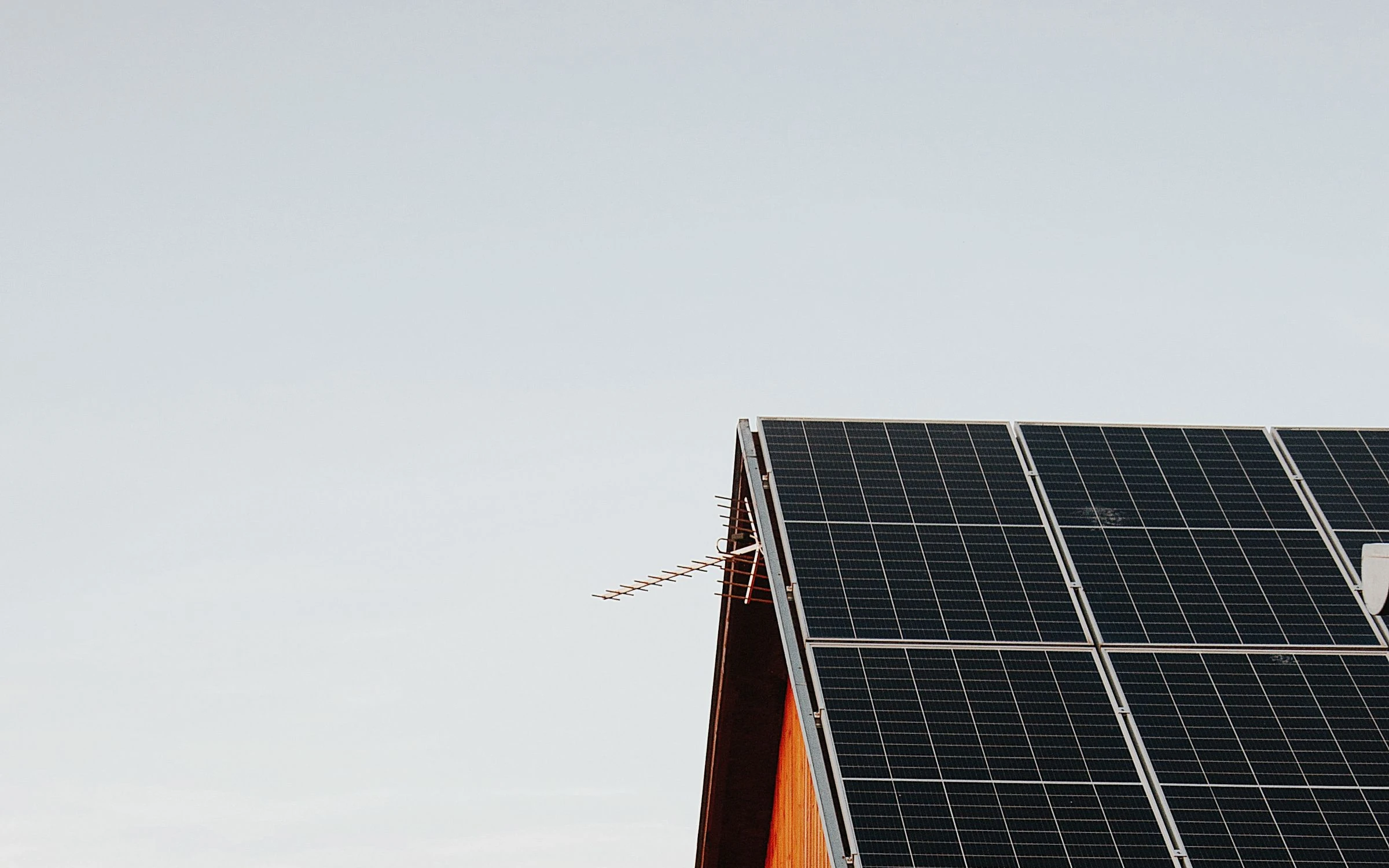 Maison équipée de panneaux photovoltaïques en toiture, au coucher du soleil