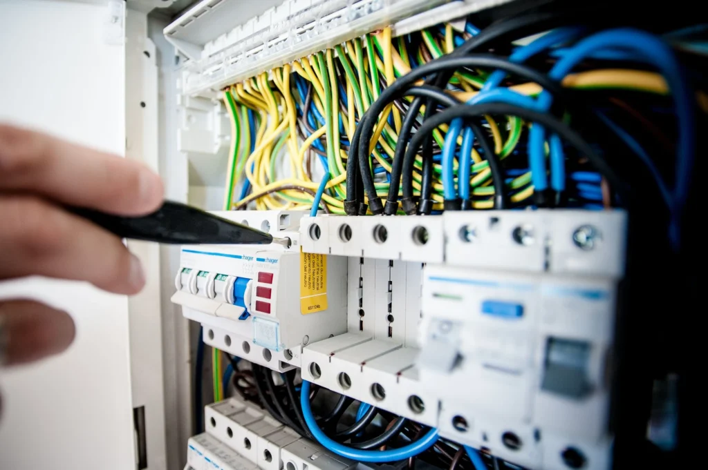 Électricien travaillant sur un tableau électrique — attestation de conformité Consuel